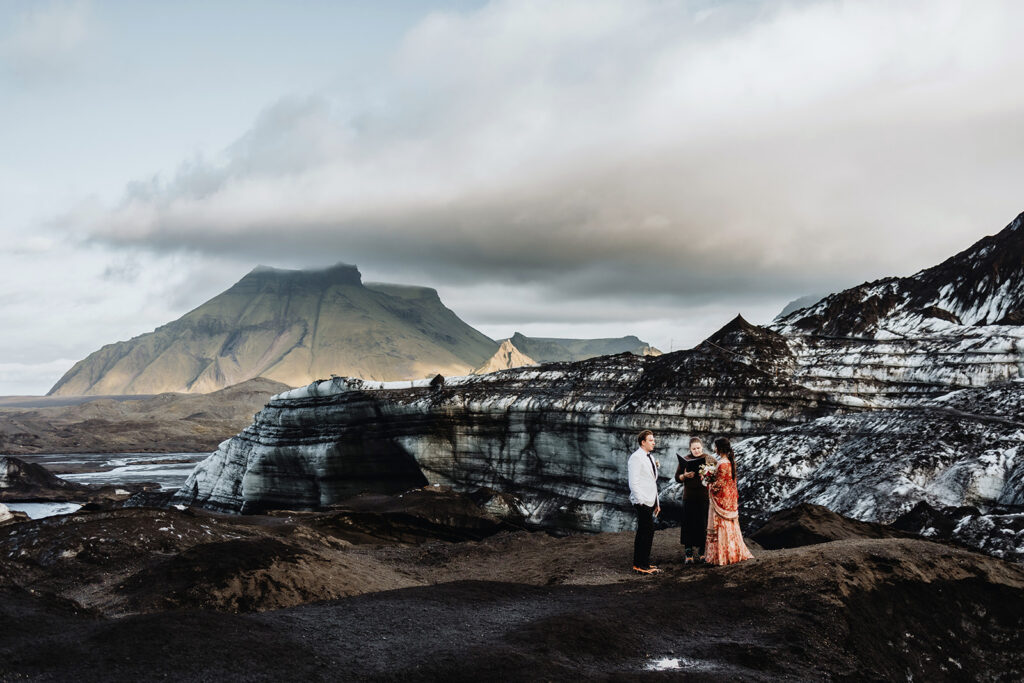 Mauli and Christian standing on a glacier near Vík, Iceland, on their elopement day