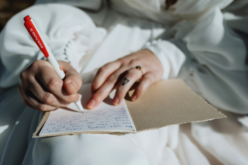 Close-up of Jade writing her vows at Dyrhólaey