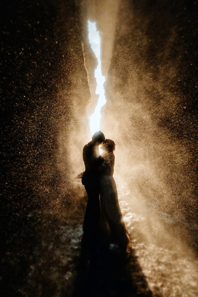 Jade and Bradley embracing inside Gljúfrabúi waterfall cave in Iceland, Junebug Best of the Best 2023 award-winning photo