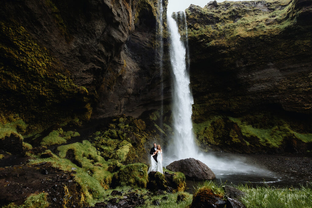 Bride and groom at Kvernufoss waterfall in South Iceland
